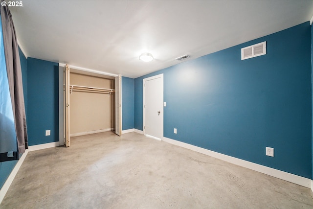 unfurnished bedroom featuring concrete floors, a closet, and baseboards