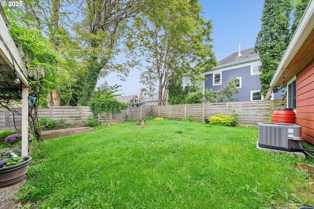 view of yard with central AC unit and a garden