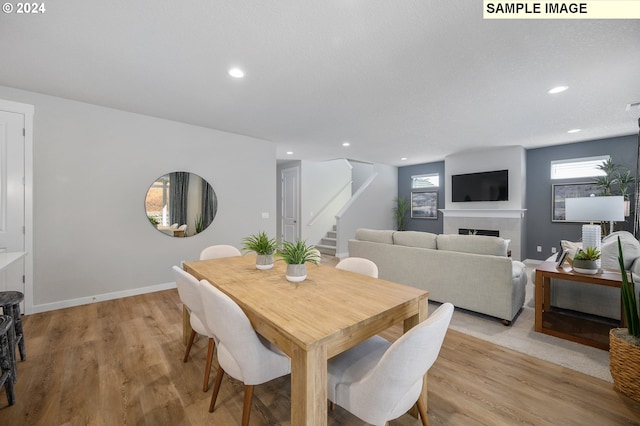 9203 S 3rd St Unit 113, Ridgefield, WA 98642 - dining space with stairs, light wood-type flooring, a fireplace, recessed lighting, and baseboards