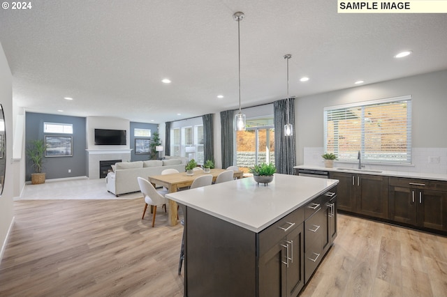 9203 S 3rd St Unit 113, Ridgefield, WA 98642 - kitchen featuring a sink, light wood-style flooring, dark brown cabinets, light countertops, and recessed lighting