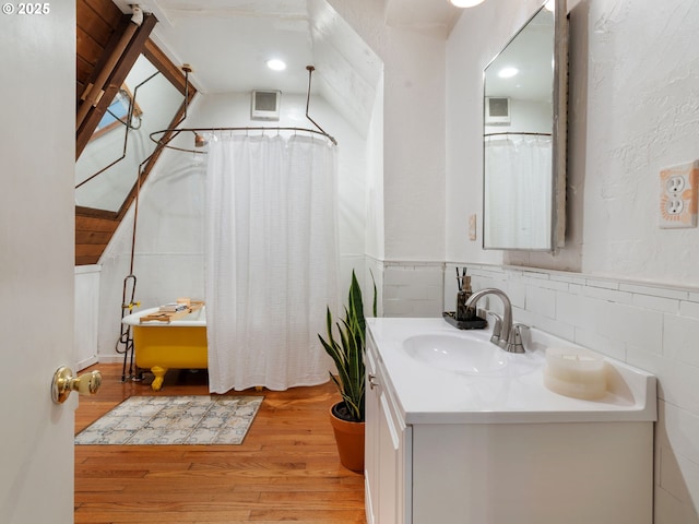 1171 Mabee Mines Rd, Washougal, WA 98671 - full bathroom featuring vanity, wood finished floors, wainscoting, a shower with shower curtain, and a bathtub
