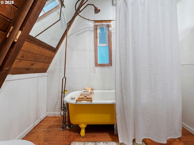 1171 Mabee Mines Rd, Washougal, WA 98671 - full bathroom with wood finished floors, a freestanding tub, concrete block wall, and a shower with curtain