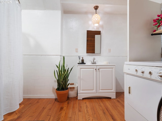 1171 Mabee Mines Rd, Washougal, WA 98671 - bathroom featuring washer / dryer, vanity, wood finished floors, and a wainscoted wall
