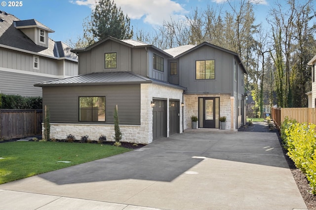 view of front of house featuring driveway, a garage, fence, and board and batten siding