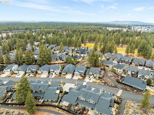 drone / aerial view featuring a residential view and a wooded view