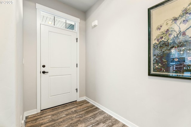 doorway featuring dark wood-type flooring and baseboards