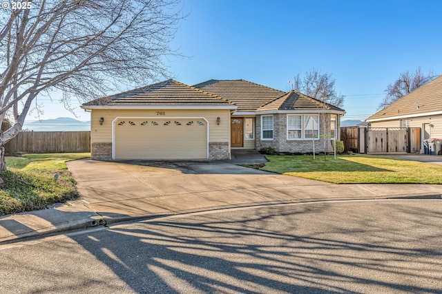 view of front of home featuring a garage, brick siding, a front yard, and fence