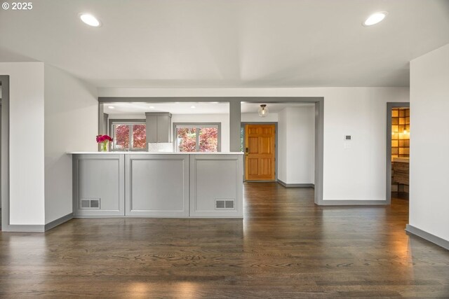 bar featuring baseboards, dark wood finished floors, and recessed lighting