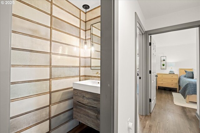 ensuite bathroom with wood finished floors and vanity