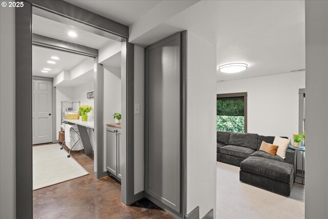 corridor with finished concrete flooring and recessed lighting