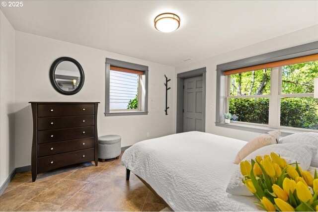 bedroom featuring baseboards and stone finish floors