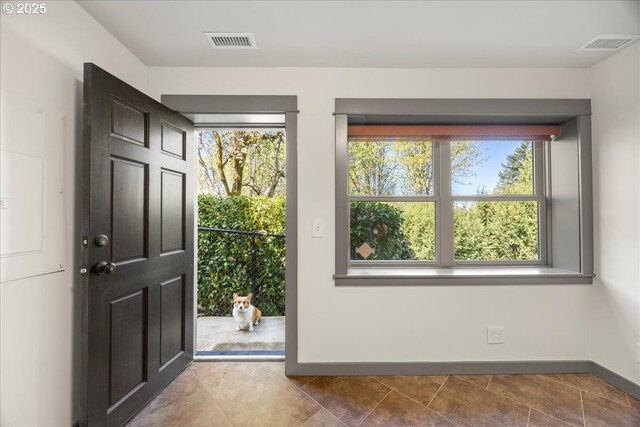 doorway to outside with baseboards and tile patterned floors