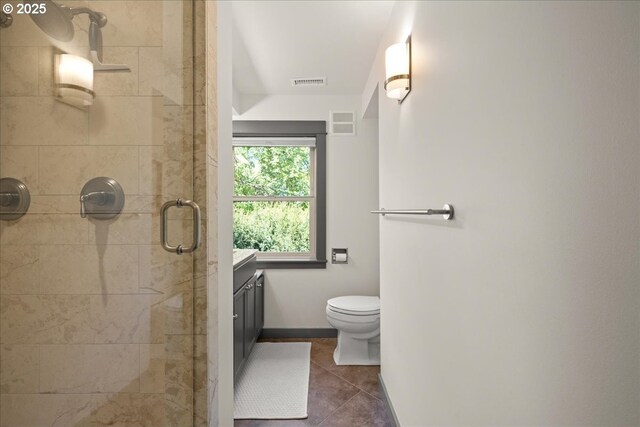 bathroom with a shower stall, tile patterned floors, vanity, toilet, and baseboards