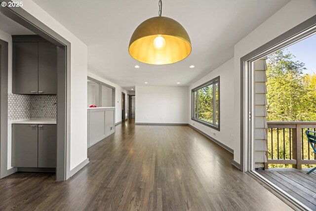 unfurnished living room with dark wood-style floors, baseboards, and recessed lighting