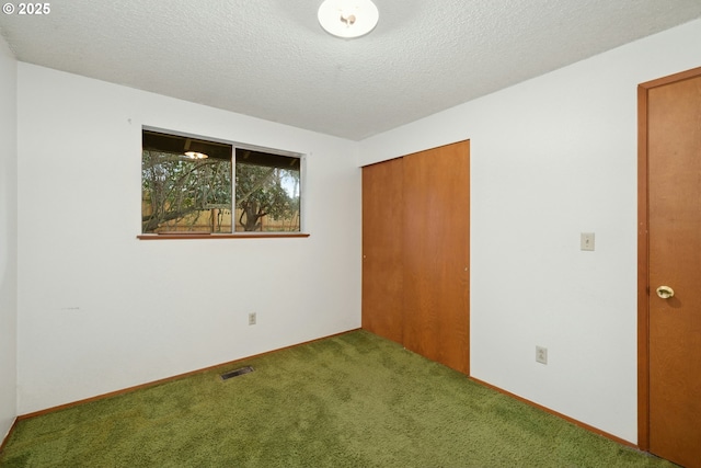 unfurnished bedroom with carpet floors, a closet, and a textured ceiling