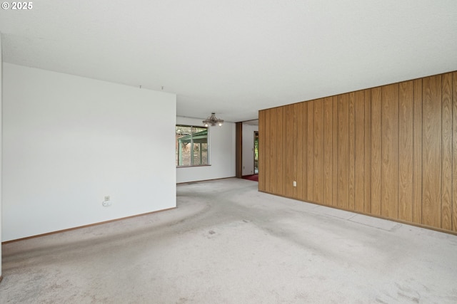 unfurnished living room featuring light colored carpet and wooden walls