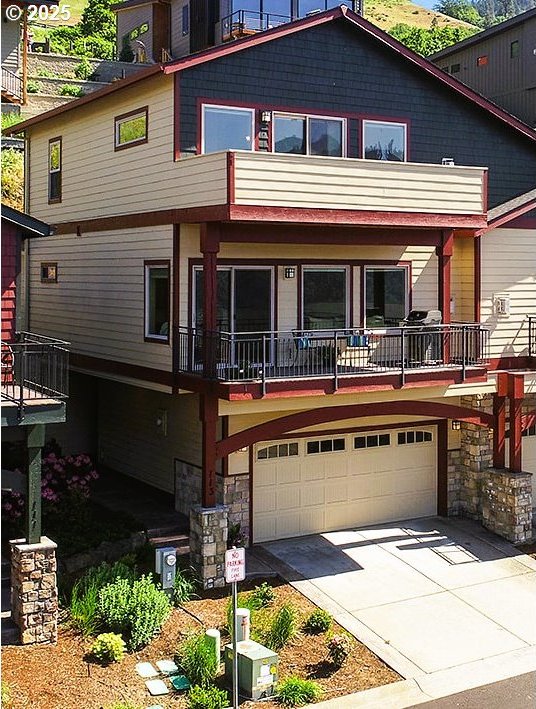 113 Ingram Pl, White Salmon, WA 98672 - view of front of house featuring a garage, stone siding, and concrete driveway