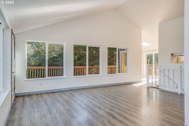 empty room featuring hardwood / wood-style floors and high vaulted ceiling