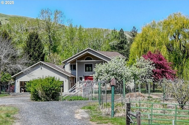 view of front facade with fence and gravel driveway