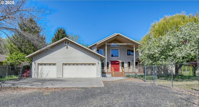 view of front facade with fence, driveway, and a garage