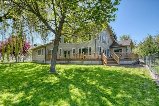 back of house with a fenced backyard, a wooden deck, and a lawn