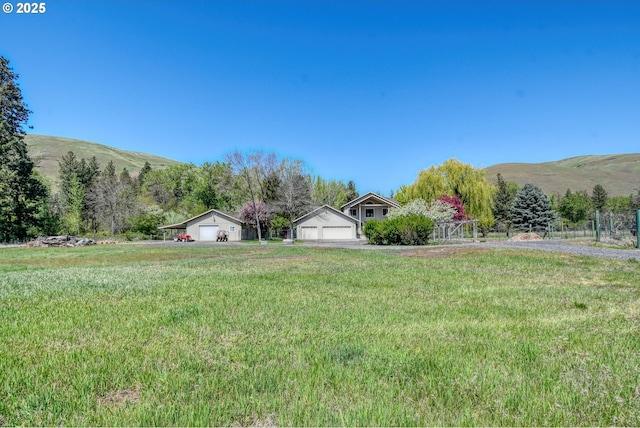 54693 Bingham Rd, Adams, OR 97810 - view of green lawn featuring a detached garage, a mountain view, an outdoor structure, and a view of countryside