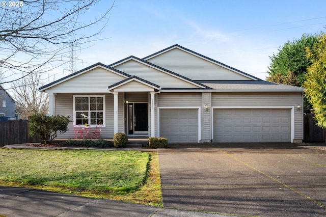 ranch-style home featuring a front lawn, fence, driveway, and an attached garage