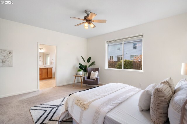 bedroom with ensuite bath, baseboards, ceiling fan, and light colored carpet