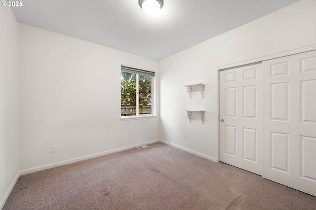 unfurnished bedroom with a closet, carpet, and baseboards