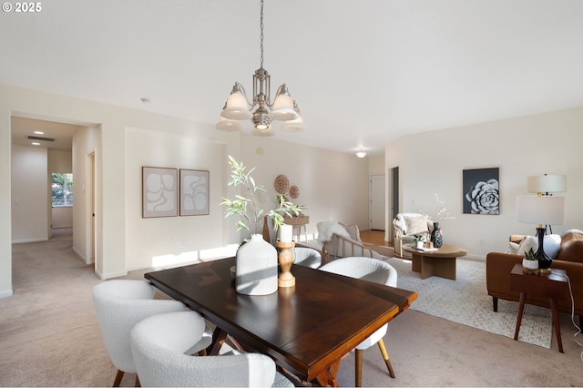 dining room featuring baseboards, a notable chandelier, and light colored carpet