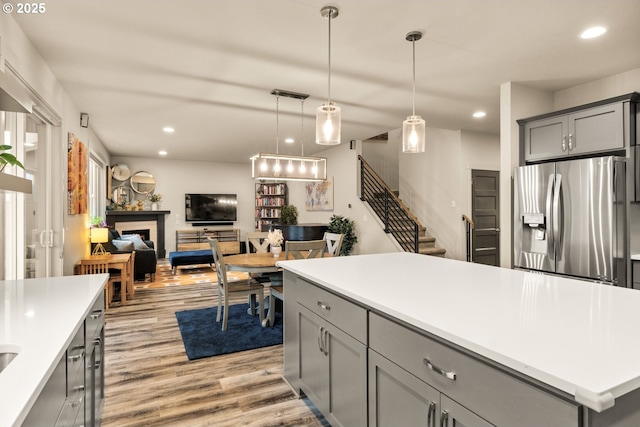 kitchen featuring light wood finished floors, visible vents, stainless steel fridge with ice dispenser, a center island, and gray cabinets