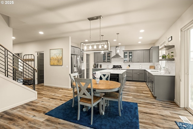 dining area with recessed lighting, visible vents, light wood-style flooring, baseboards, and stairs