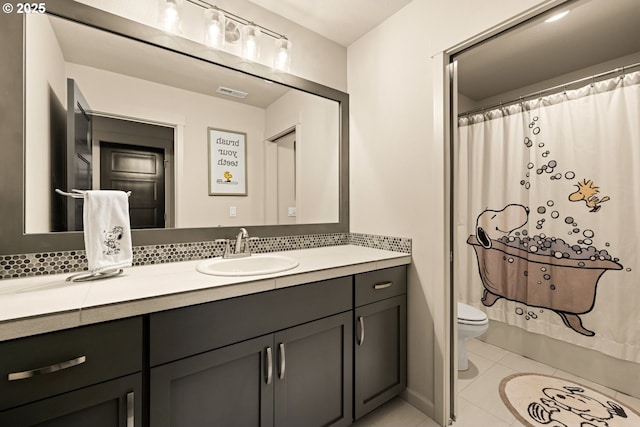 bathroom with toilet, visible vents, vanity, tile patterned floors, and tasteful backsplash