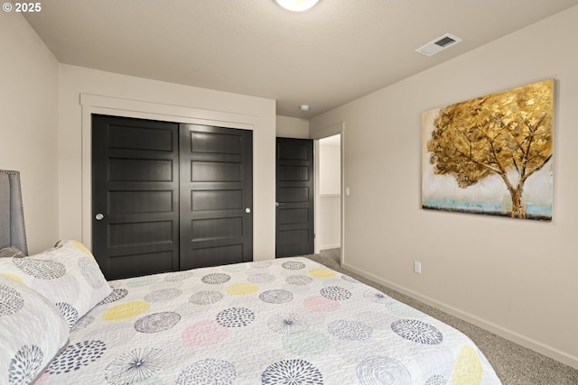 carpeted bedroom featuring baseboards, visible vents, and a closet