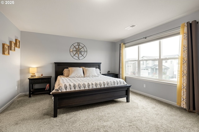 bedroom with light carpet, visible vents, and baseboards