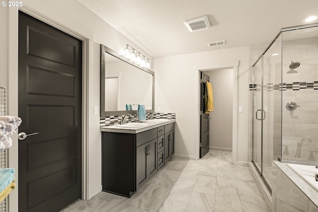 bathroom with marble finish floor, vanity, a shower stall, and visible vents