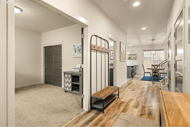 hallway with carpet, baseboards, wood finished floors, and recessed lighting