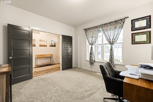 carpeted home office featuring baseboards