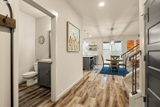 hall featuring recessed lighting, stairway, baseboards, and wood finished floors