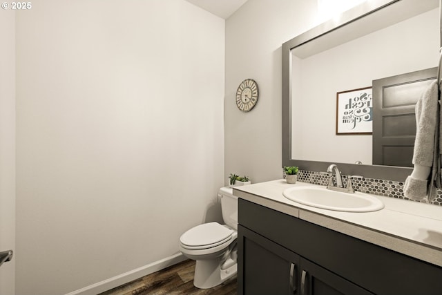 bathroom featuring vanity, wood finished floors, toilet, and baseboards