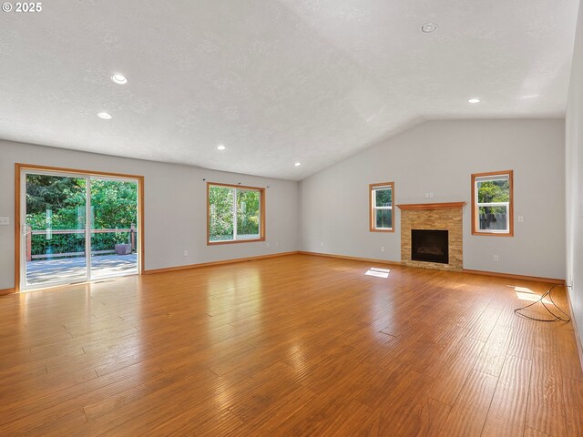 unfurnished living room with light wood-style flooring, a fireplace, lofted ceiling, recessed lighting, and baseboards