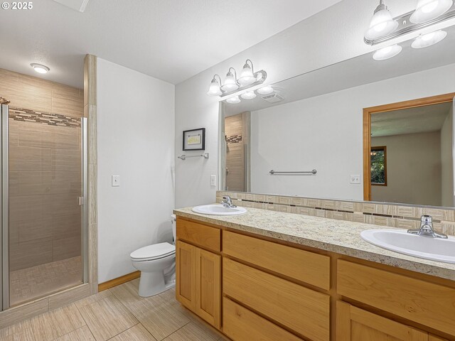 full bathroom with a shower stall, double vanity, and toilet