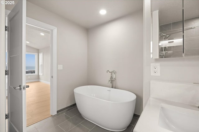 35505 Upper Loop Rd, Pacific City, OR 97135 - full bath featuring a soaking tub, baseboards, vanity, tile patterned floors, and recessed lighting
