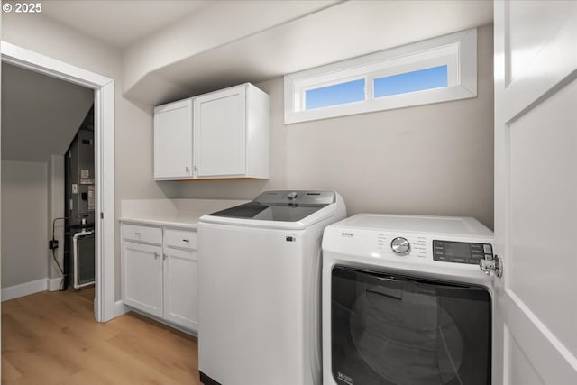 35505 Upper Loop Rd, Pacific City, OR 97135 - laundry room with washer and clothes dryer, light wood-style flooring, and cabinet space