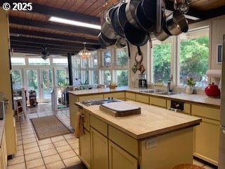 53742 Rosa Rd, Bandon, OR 97411 - kitchen with wooden ceiling, light countertops, gas cooktop, light tile patterned floors, and a peninsula