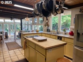 53742 Rosa Rd, Bandon, OR 97411 - kitchen featuring stainless steel fridge with ice dispenser, wood ceiling, light countertops, a sink, and light tile patterned floors