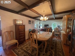 53742 Rosa Rd, Bandon, OR 97411 - dining space with wood finished floors, coffered ceiling, beam ceiling, and a chandelier