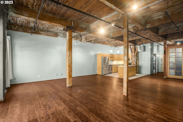 basement featuring stainless steel refrigerator, hardwood / wood-style floors, and a wall mounted air conditioner