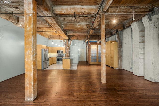 basement with stainless steel refrigerator and dark hardwood / wood-style flooring