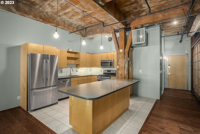 kitchen featuring hanging light fixtures, stainless steel appliances, and a high ceiling